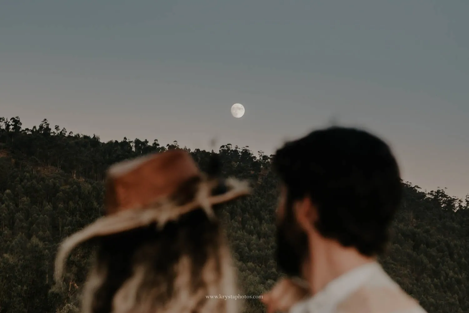 Romantic editorial wedding couple looking at the moon during golden hour in Portugal