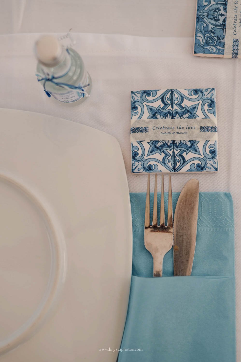 Greek island beach wedding table details with blue tile invitation and Mediterranean aesthetic