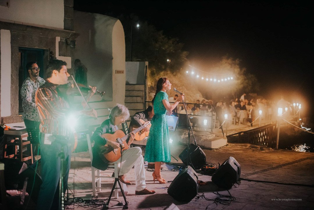 Candlelit seaside wedding dinner in Greece with newlyweds, guests, and live swing music by Gadjo Dilo