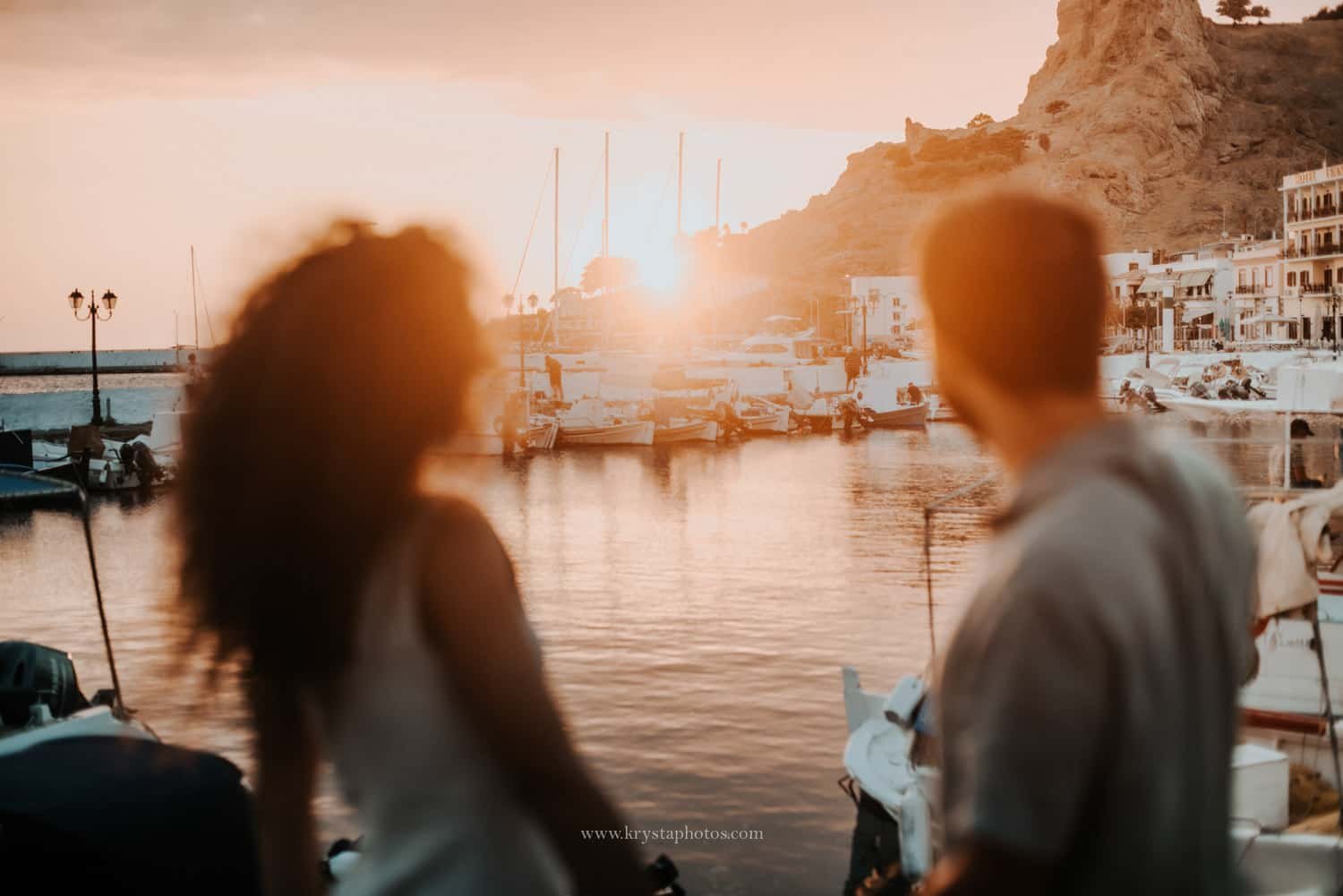 Couple watching the sunset overlooking the whitewashed village of Myrina, in Lemnos island, Greece during a romantic engagement session